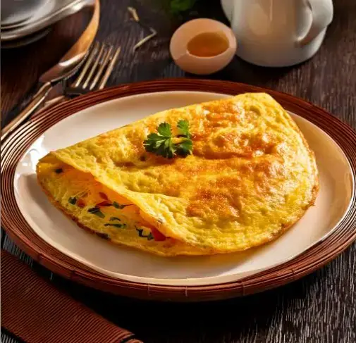 Gordon Ramsay's signature omelette garnished with fresh herbs and served with a side of smoked salmon