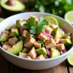 Mixing Mexican Tuna Salad in a bowl with fresh ingredients like tuna, avocado, and cilantro